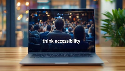 A laptop with a live event streaming, with a caption at the bottom of the screen saying Think Accessibility.