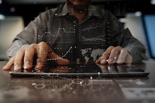 A business persons hands working on laptop computer with digital layer business strategy and social media diagram on wooden desk